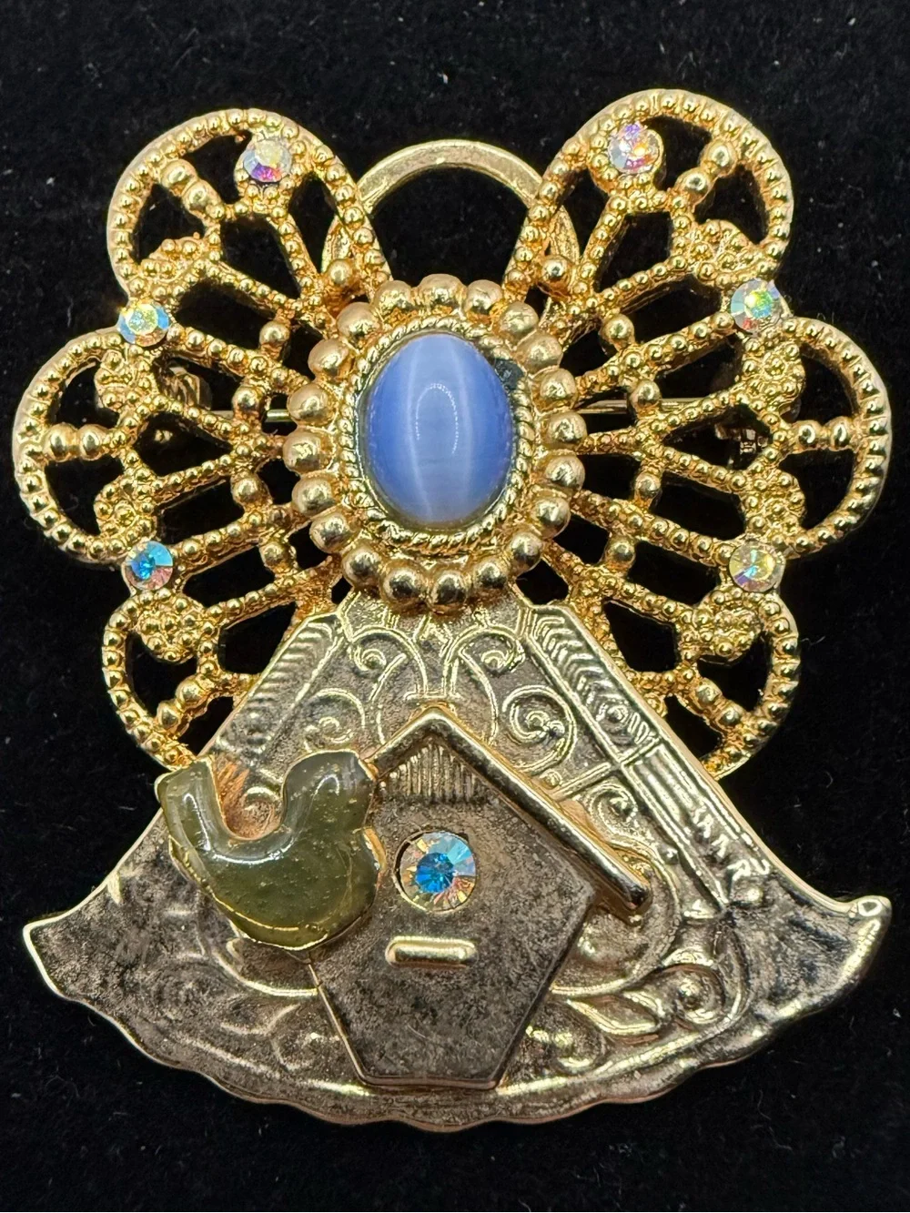 vintage gold-tone angel brooch features a filigree halo, a blue cabochon stone…
